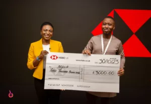 A black woman and a black man holding a cardboard cheque